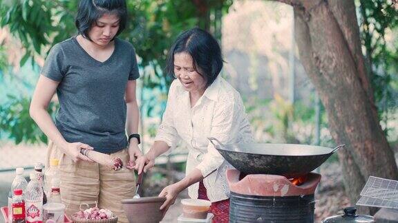 亚洲妈妈和女儿在家里烹饪传统食物