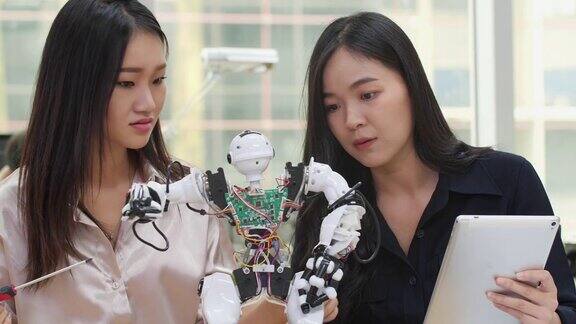 亚洲女工程师在实验室组装和测试机器人反应建筑师设计电路会议分享技术思想和协作开发机器人