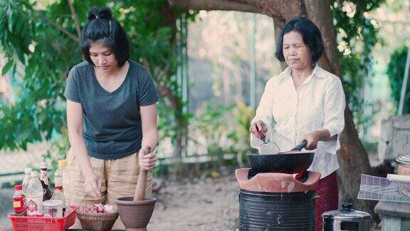 亚洲妈妈和女儿在家里烹饪传统食物