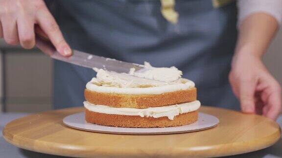 在制作蛋糕的过程中将奶油涂在海绵蛋糕上