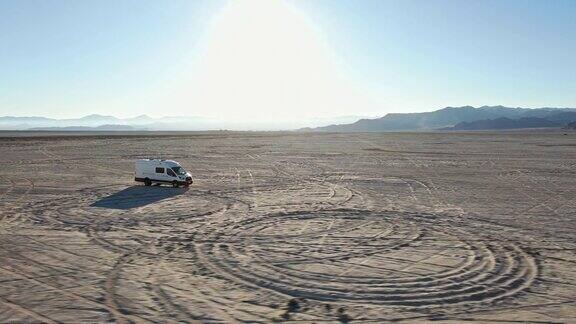 无人机视图改装的短跑露营车行驶在中午的博纳维尔盐滩中部