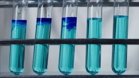 近距离地将溶液加入装有蓝色混合物的烧瓶中现代实验室化学反应和实验化学研究