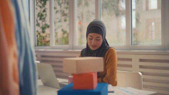 穆斯林女性小企业主在笔记本电脑和网上服装店工作