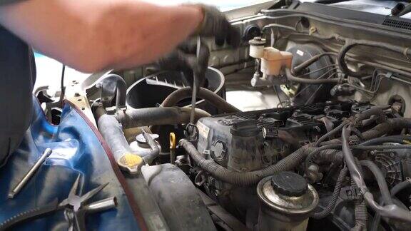 一个修理工修理一辆旧车的4k电影在汽车引擎盖下检查碳水化合物和发动机的工作