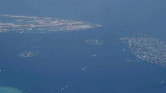 从飞机上俯瞰马尔代夫的一个热带岛屿的海滩这里有白色的沙滩和水上小屋