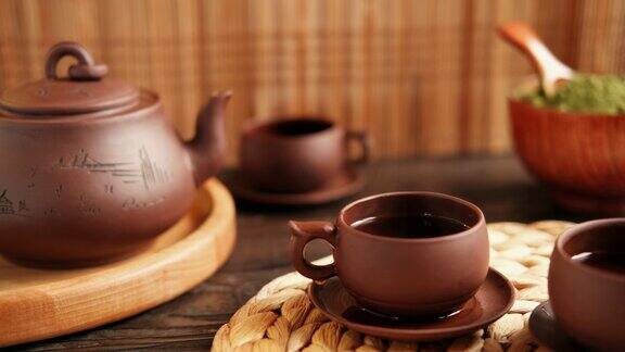 茶道亚洲传统茶具正宗茶具套装把茶从茶壶倒进茶杯的人竹托盘的生活方式健康平衡健康泡茶设备