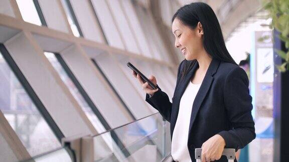 亚洲年轻女商人在机场使用智能手机
