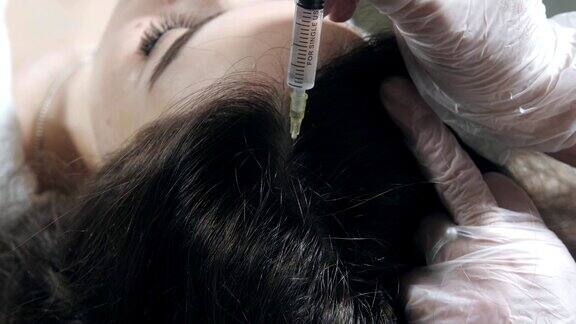英俊的女人被打了一针这个过程让医生戴上白手套中间疗法推动以加强头发和它们的生长