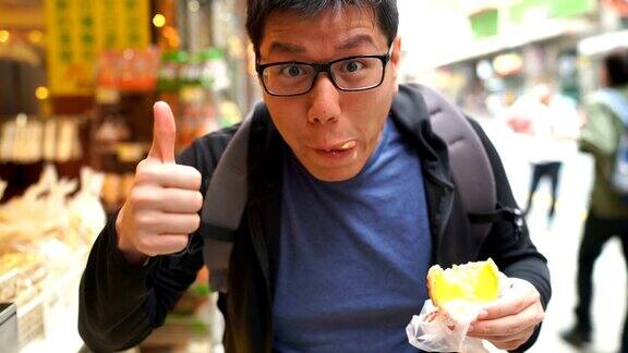 在香港街头吃蛋挞的亚洲人