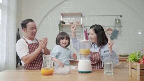 亚洲家庭爸爸妈妈和儿子帮忙做饭在厨房做冰沙