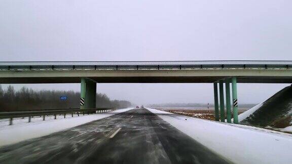 在可怕的多雪多风的天气里重型货车在公路上行驶透过挡风玻璃的视野-驾驶员视角移动视频