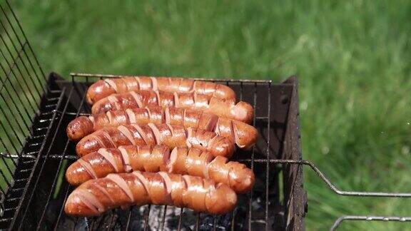 美味的烤香肠带切口的烤香肠准备在野餐时吃热狗香肠在户外用木炭烤着烧烤