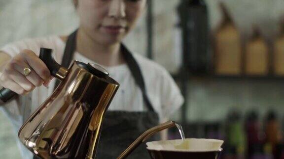 可爱的日本咖啡师将热水倒在磨碎的咖啡豆上