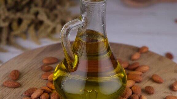 在木制背景上以杏仁坚果为背景在壶中或瓶子中加入杏仁油