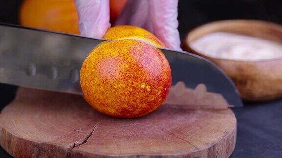 在厨房的桌子上切红橘子