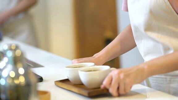 4K亚洲女服务员在咖啡厅吧台为顾客提供热咖啡