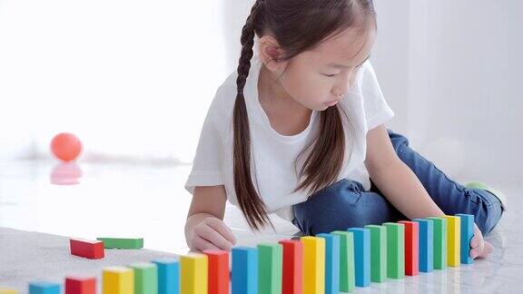 亚洲女孩在学校的地板上玩木制玩具积木领导成就教育决心和未来学前知识ม创新
