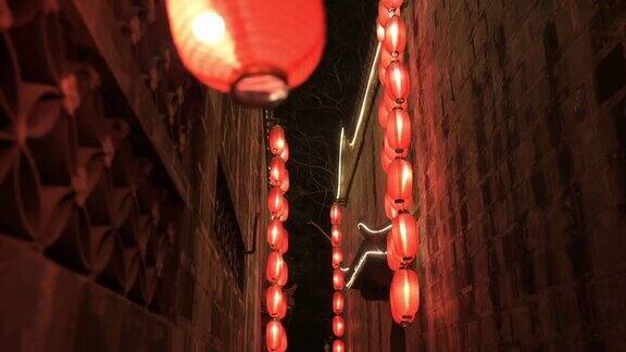 沿着右边的石墙向前走穿过中国古庙的狭窄走廊点燃了红灯笼四处悬挂着照明灯传统装饰节日庆典