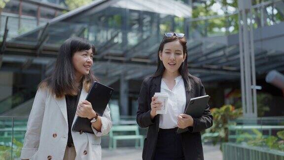 亚洲的商业女性会在休息时间喝咖啡在公共场所一起散步享受交谈