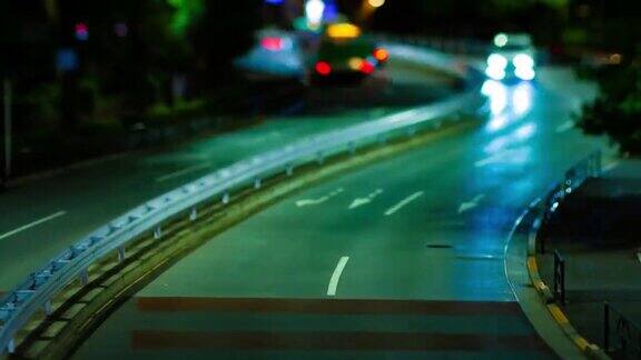 青山斜交的城市街道上的小型交通堵塞的夜间时间推移