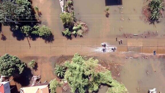 西尔德拍摄的垂直摩托车行驶在被洪水淹没的街道上穿过一个乡村