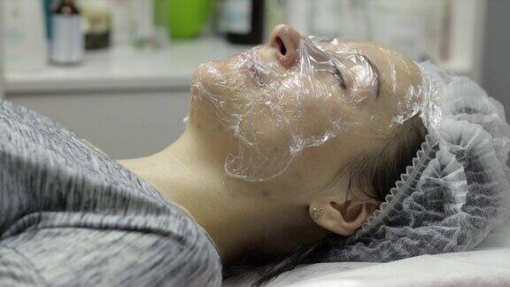 女人用口罩在她的脸上做美容程序清洁mesotherapy
