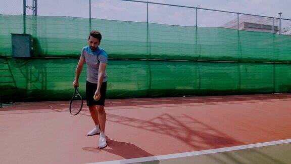 一名中东男子准备在网球场上发球的慢镜头行走轨道