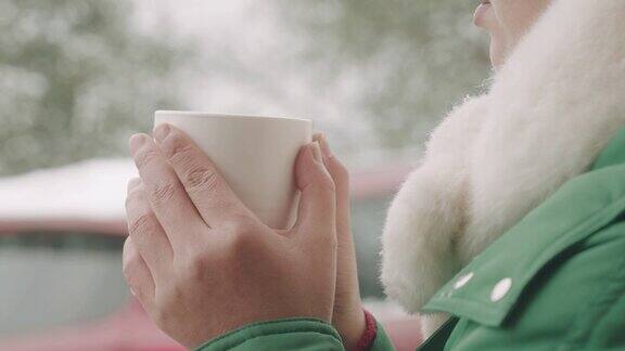下雪天喝茶或咖啡的女人