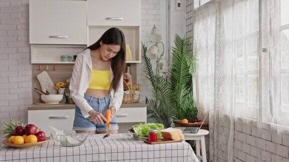 4k视频片段显示亚洲少女用水果刀做蔬菜沙拉在厨房一起在烹饪中快乐生活的娱乐生活中很少奢侈可持续的生活方式