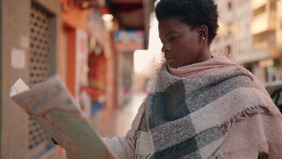 年轻的非洲裔美国妇女在街上看城市地图