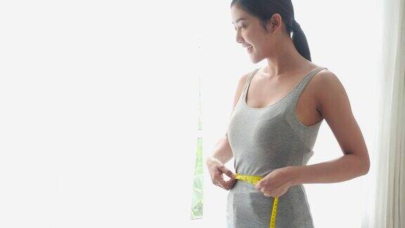 亚洲美丽的女人测量腰围与快乐的情绪减肥饮食计划美容健康的好处和估计腰围