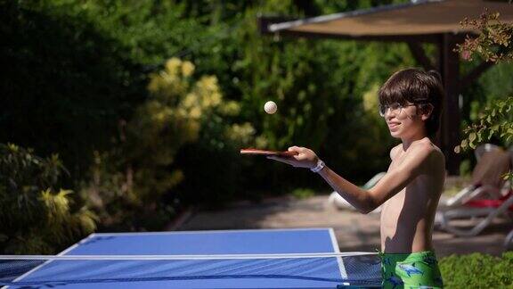 一个慢动作小男孩正在泳池边训练打乒乓球