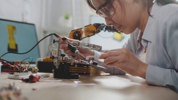 女工程师正在用烙铁修理电路板
