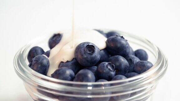益生菌开菲尔酸奶倒蓝莓碗旋转白色背景