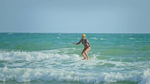 女冲浪者在阳光明媚的日子里骑着海浪冲浪