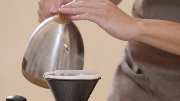 专业的咖啡师将水倒在过滤器里的咖啡渣上这是一个手工过程