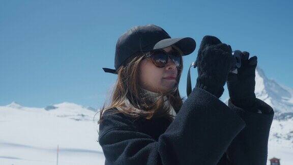亚洲女摄影师在瑞士雪山拍摄度假照片