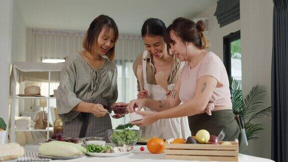 年轻的亚洲女性朋友在家里的餐桌上准备素食和烹饪沙拉生活方式健康饮食享受自然生活和植物性饮食