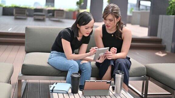 两个年轻的亚洲女商人在搭建露台上成功会面业务客户咨询