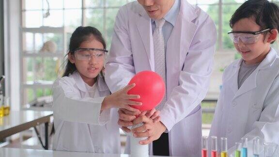 年轻的科学家女孩将化学物质倒入气球中然后发生反应产生气体并扩大气球的大小与儿童的兴奋和乐趣