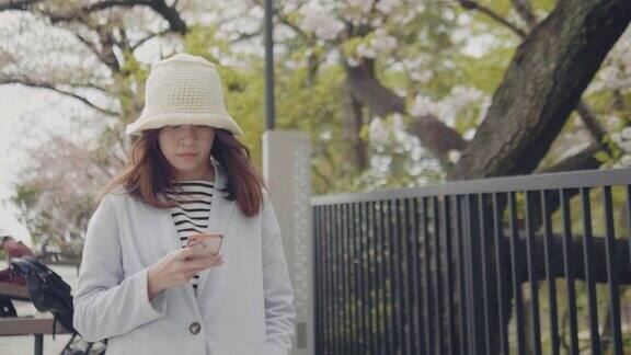 女游客在东京市内行走时使用和打字短信