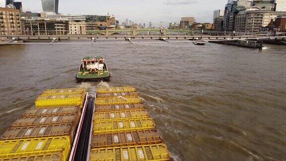 泰晤士河上一艘拖着驳船的船的无人机视图