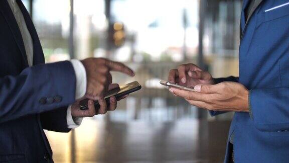 商人用智能手机握手慢动作
