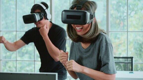 Metaverse一对年轻夫妇在VR头戴式设备中玩拳击游戏在家进行虚拟现实踢球训练