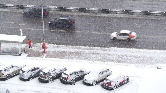 时间流逝从上面看到公交车站和清理人行道积雪的工人