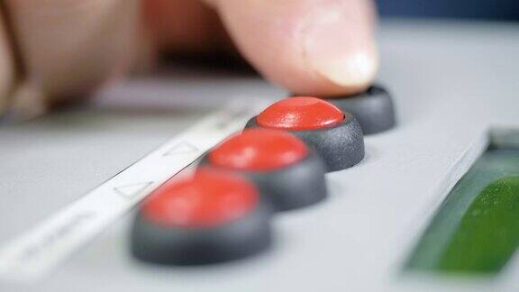 特写手指按下控制面板上的红色和黑色按钮