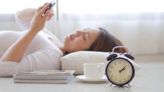年轻女子在家里用智能手机和咖啡休息时间放松