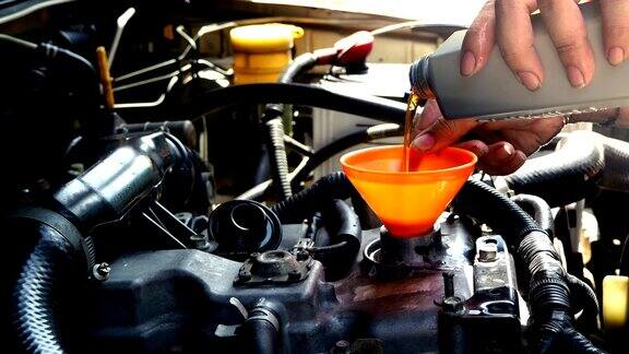 汽车修理工将新的润滑油注入发动机汽车保养