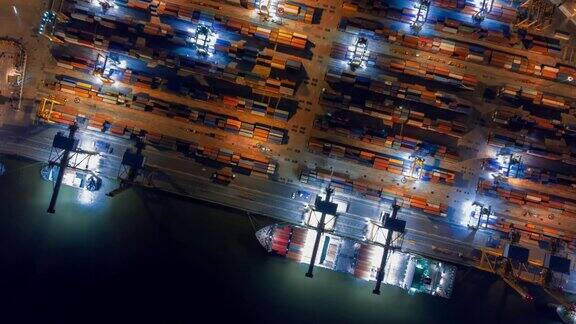 鸟瞰图无人机延时或超延时在泰国曼谷的工业港口与许多集装箱船船和大型起重机在夜间工作