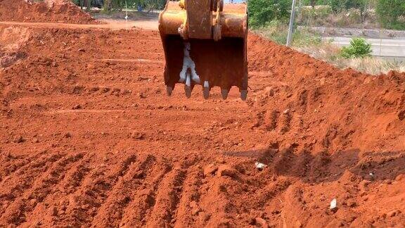 现场挖掘机斗在阳光下挖土施工